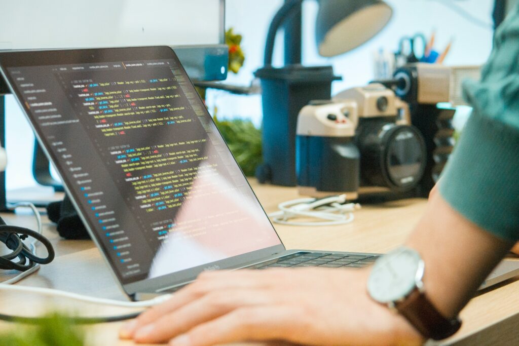 a person writing code on a laptop at a desk