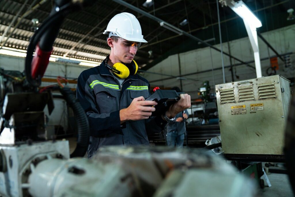a person using equipment in manufacturing and automobile | Elevating the automotive and industrial manufacturing value chain with Oracle and IBM