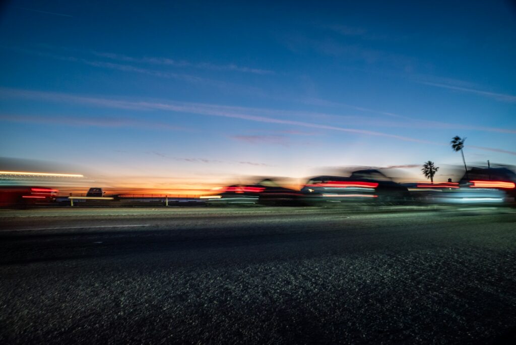 image of blurry cars as the sun is setting | transportation waste