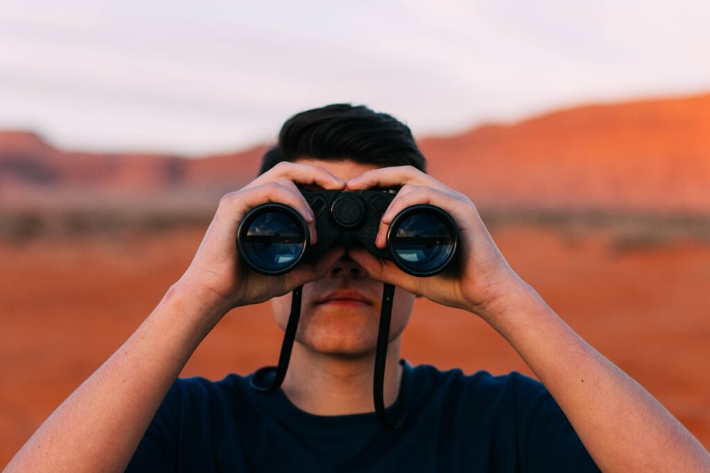 a man looking thorough binoculars | Leadership and AI share the spotlight in the future of work