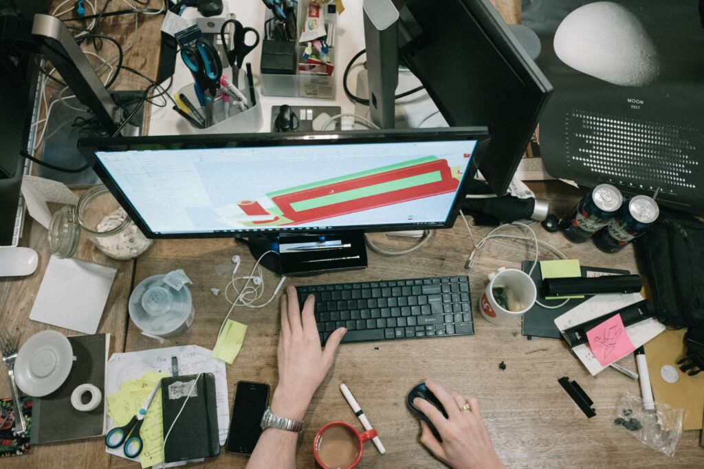a computer on a desk in a messy and cluttered environment | The definition of madness. Still driving ERP business change without due care and attention