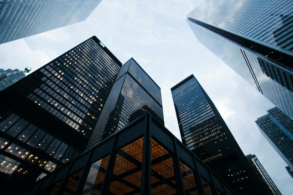 Dark glass skyscrapers, with a view looking upwards on a cloud day | KPMG